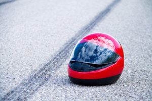 an accident with a motorcycle. traffic accident, skid marks and helmet on road