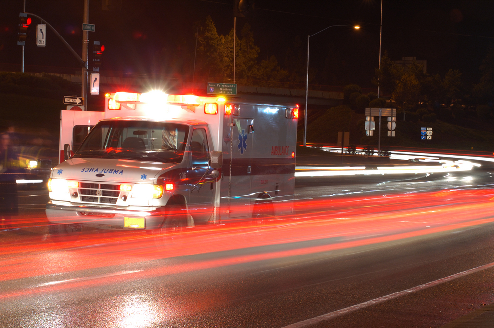 Ambulance standing in night traffic at a motor vehicle accident in early winter