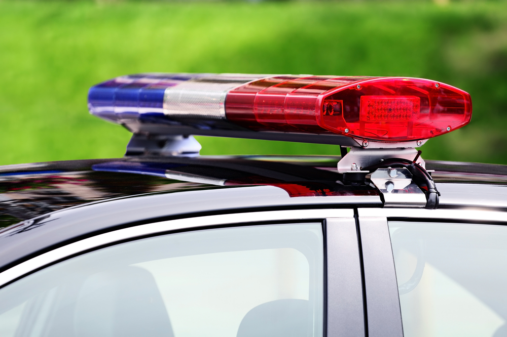 police car with siren light closeup on green background, selective focus